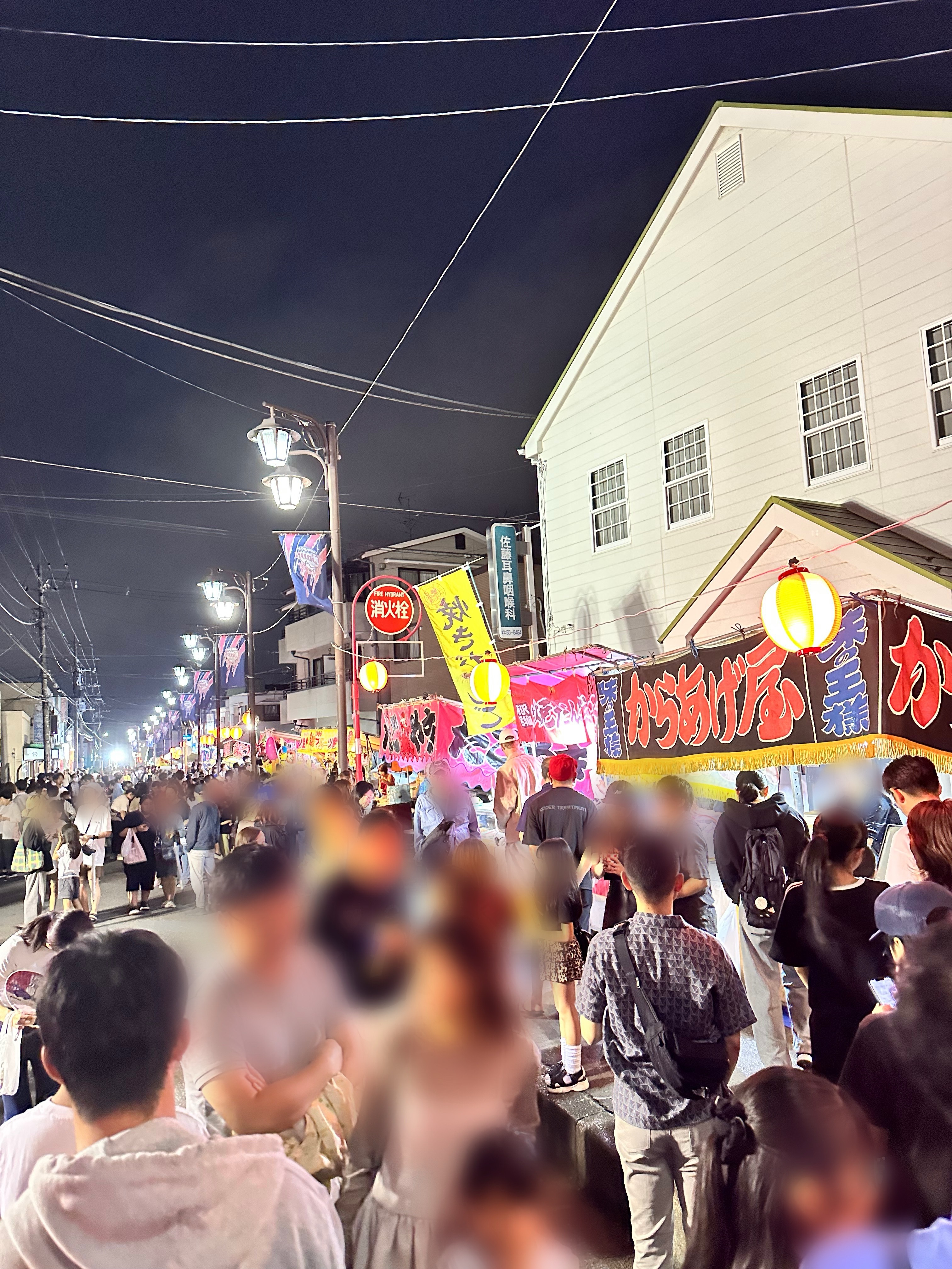 屋台グルメを楽しむ家族連れや商店街の賑わい